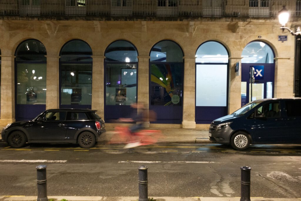 Cycliste traversant les Allées de Tourny à Bordeaux au crépuscule