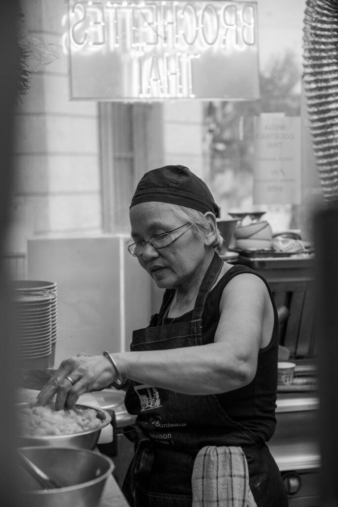 Mme Tik préparant un plat dans les cuisines du TUK TIK Thaï Food District dans le quartier Saint-Michel à Bordeaux